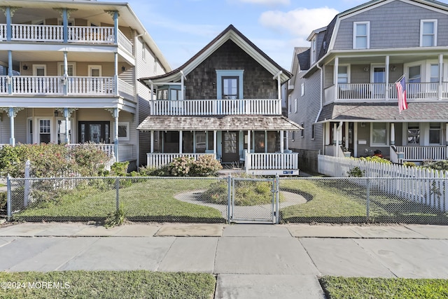 view of front of property featuring a fenced front yard, a gate, covered porch, and a front lawn