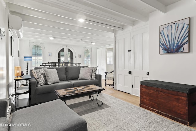 living room featuring arched walkways, a healthy amount of sunlight, a wall mounted air conditioner, and wood finished floors