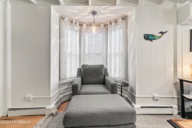 sitting room with a baseboard heating unit, a healthy amount of sunlight, and light hardwood / wood-style floors