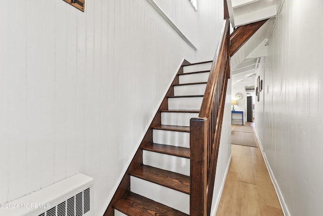 staircase with baseboards and wood finished floors