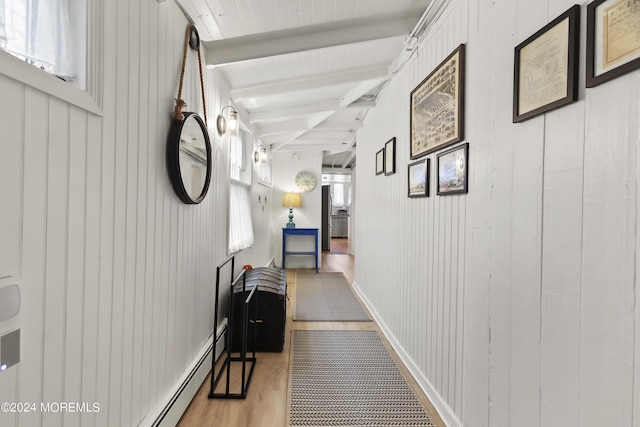 hallway featuring baseboards, beamed ceiling, and wood finished floors