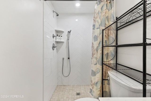 bathroom featuring tiled shower and toilet