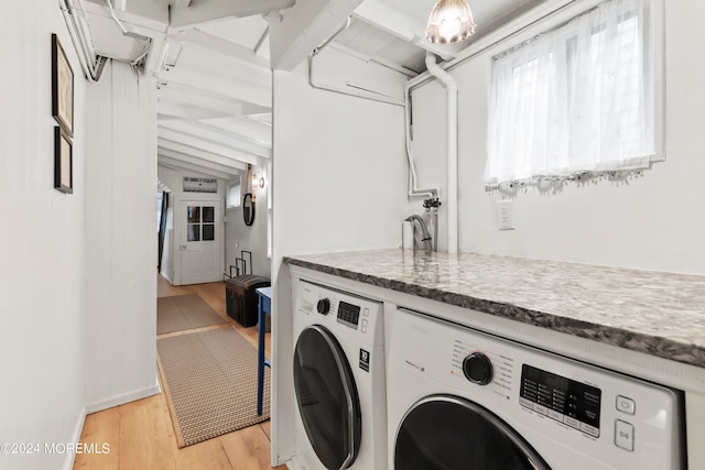 washroom with washing machine and clothes dryer and light hardwood / wood-style floors