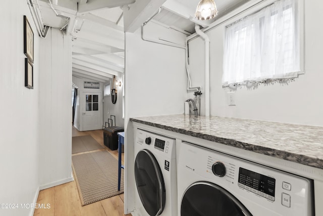 clothes washing area with light wood-type flooring and washing machine and clothes dryer