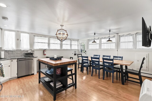 kitchen with decorative light fixtures, dishwasher, light hardwood / wood-style floors, a chandelier, and white cabinets