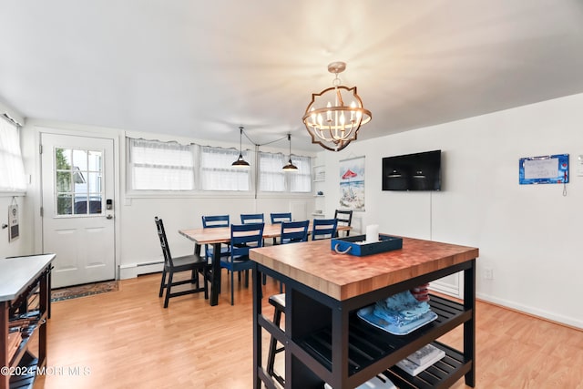 dining room featuring baseboard heating, a notable chandelier, and light hardwood / wood-style floors