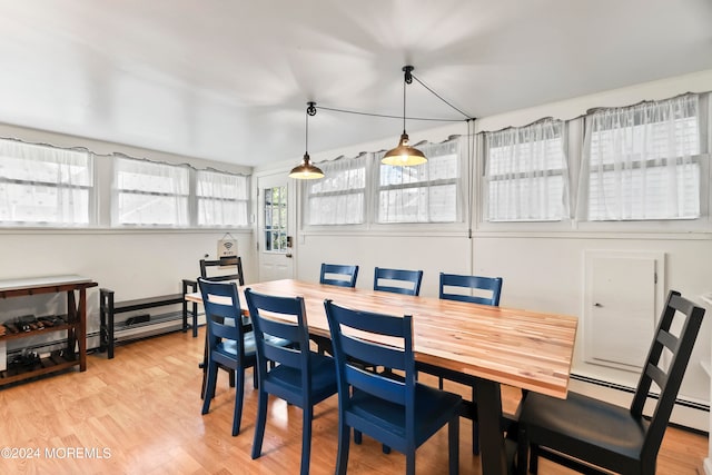 dining room with a baseboard heating unit and light hardwood / wood-style floors