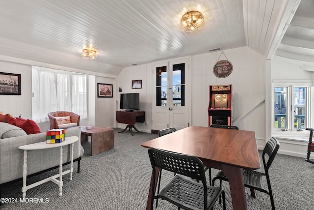 carpeted dining area with lofted ceiling