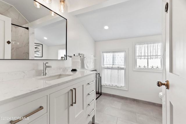 bathroom featuring tile patterned flooring, toilet, a tile shower, lofted ceiling, and vanity