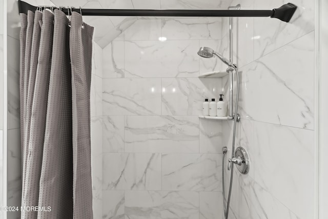 full bathroom with a marble finish shower