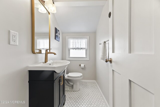 bathroom featuring tile patterned floors, vaulted ceiling, toilet, and vanity