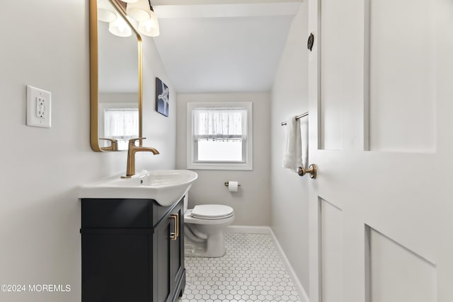 bathroom with baseboards, toilet, tile patterned flooring, vaulted ceiling, and vanity