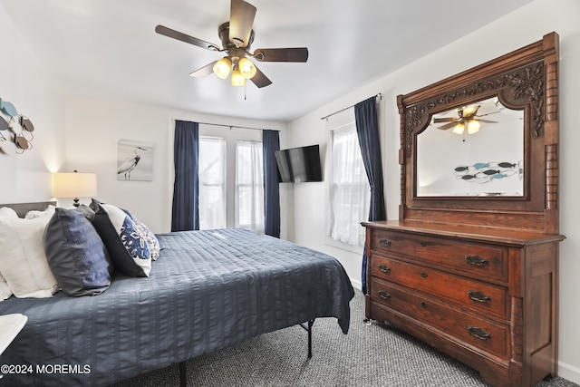 carpeted bedroom with ceiling fan and baseboards