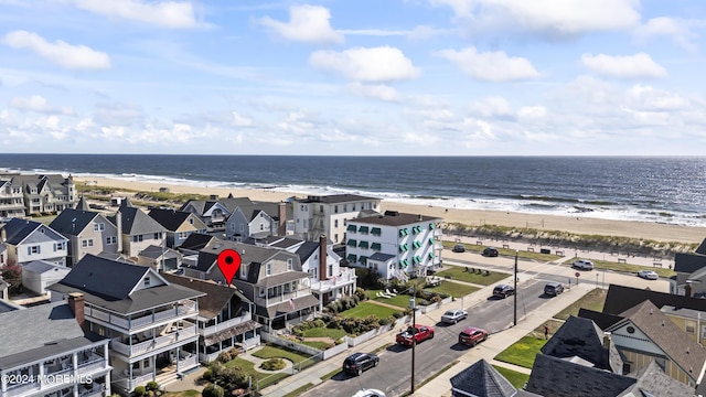 birds eye view of property featuring a water view, a residential view, and a beach view