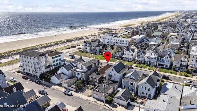 drone / aerial view featuring a water view, a residential view, and a view of the beach