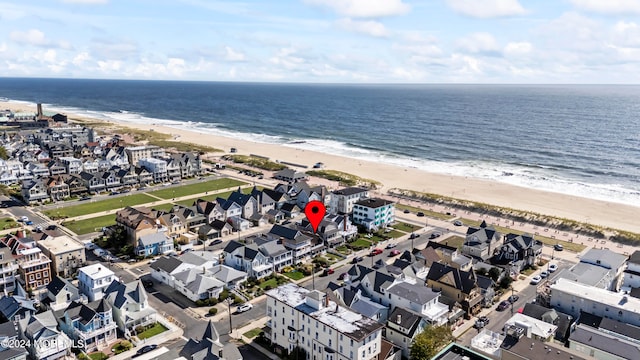 drone / aerial view featuring a view of the beach and a water view