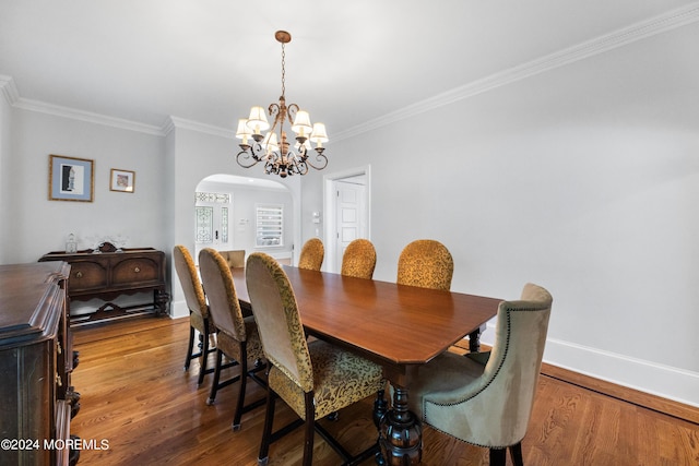 dining space featuring hardwood / wood-style floors, crown molding, and a chandelier