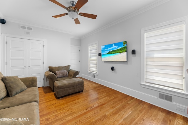 living room featuring light wood-type flooring, ornamental molding, built in shelves, and ceiling fan