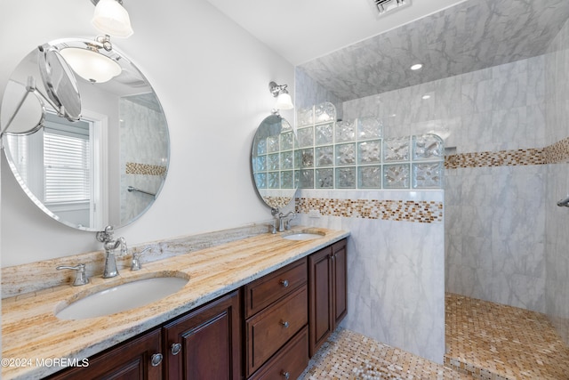 bathroom featuring tiled shower and vanity