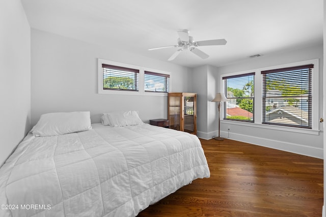 bedroom with ceiling fan, multiple windows, and hardwood / wood-style floors