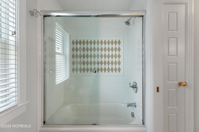 bathroom featuring combined bath / shower with glass door and a wealth of natural light