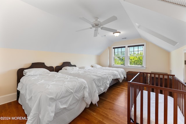 bedroom with dark wood-type flooring, vaulted ceiling, and ceiling fan