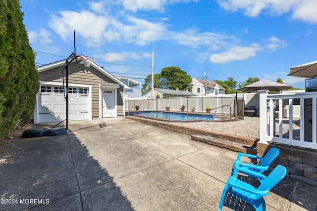 view of patio featuring an outdoor structure, a garage, and a fenced in pool