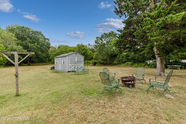 view of yard featuring a fire pit and a storage unit