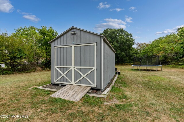 view of outbuilding with a yard and a trampoline