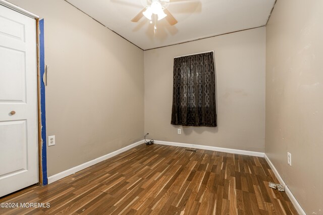 empty room with dark wood-type flooring and ceiling fan