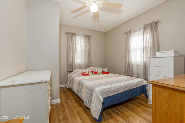 bedroom featuring multiple windows, ceiling fan, and light hardwood / wood-style floors