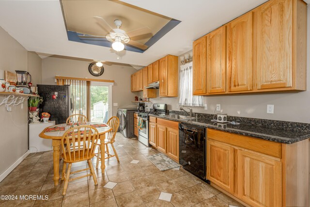 kitchen featuring appliances with stainless steel finishes, sink, a tray ceiling, ceiling fan, and washing machine and dryer