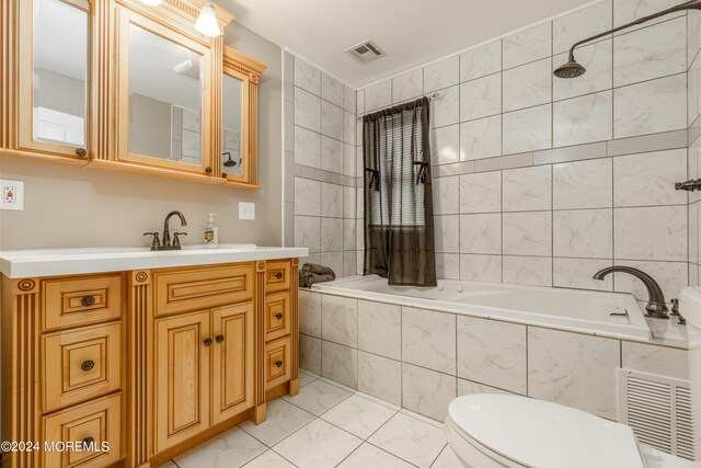 full bathroom featuring tiled shower / bath combo, vanity, toilet, and tile walls