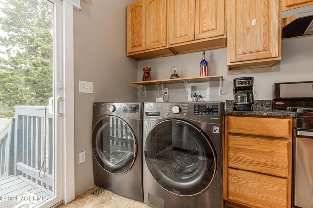 clothes washing area featuring light tile patterned floors, plenty of natural light, and washer and dryer