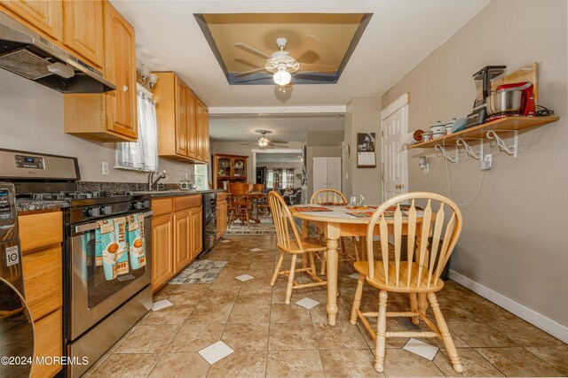 kitchen with stainless steel stove, sink, black dishwasher, a raised ceiling, and ceiling fan