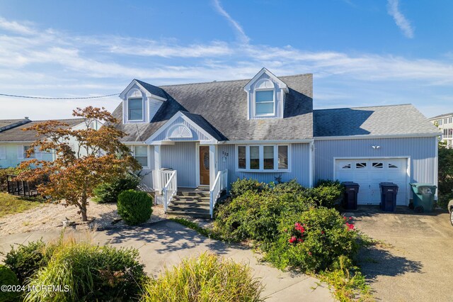 cape cod home with a garage