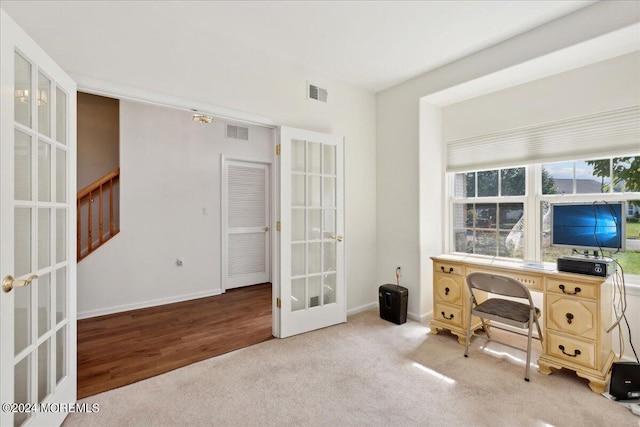 home office with french doors and light hardwood / wood-style floors