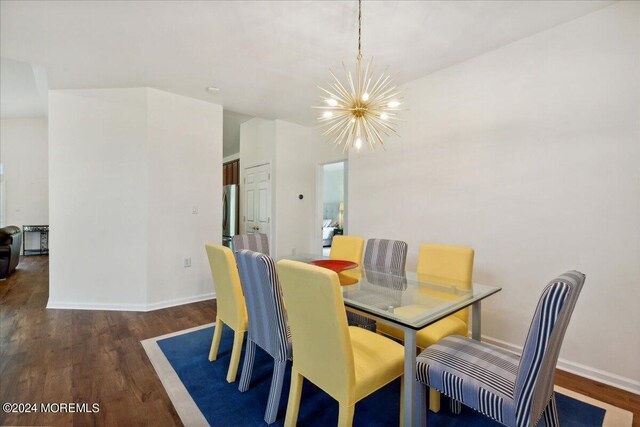 dining area with dark wood-type flooring and a chandelier