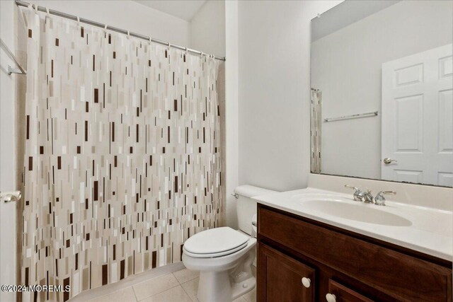 bathroom featuring a shower with shower curtain, tile patterned flooring, toilet, and vanity