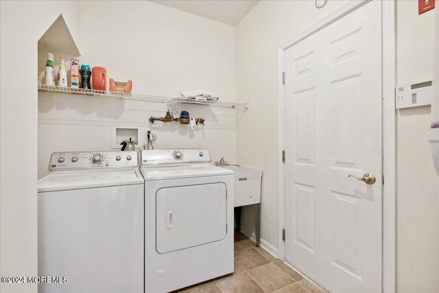 clothes washing area with independent washer and dryer, light tile patterned floors, and sink