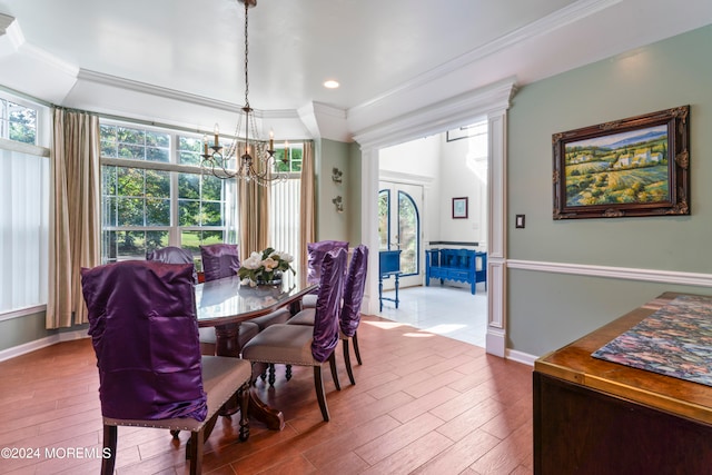 dining area featuring an inviting chandelier, hardwood / wood-style flooring, and crown molding