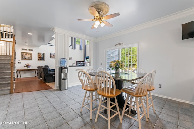 dining room with tile patterned flooring, ceiling fan, and crown molding