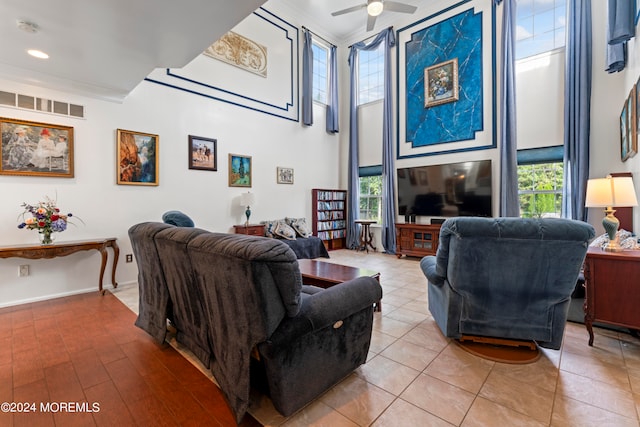 living room featuring a wealth of natural light, ceiling fan, and light wood-type flooring