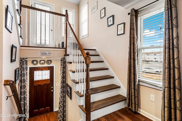 staircase featuring baseboards and wood finished floors