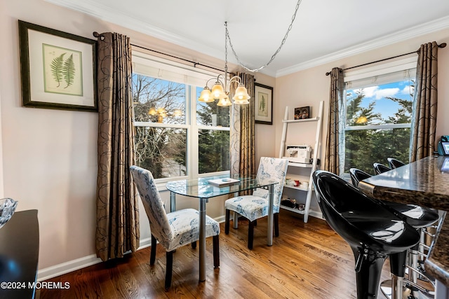 dining area featuring crown molding, wood finished floors, baseboards, and a chandelier