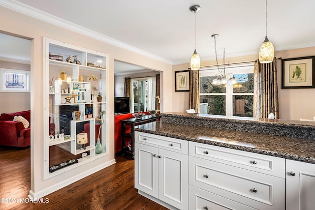 kitchen featuring pendant lighting, ornamental molding, an inviting chandelier, dark wood-style floors, and white cabinets