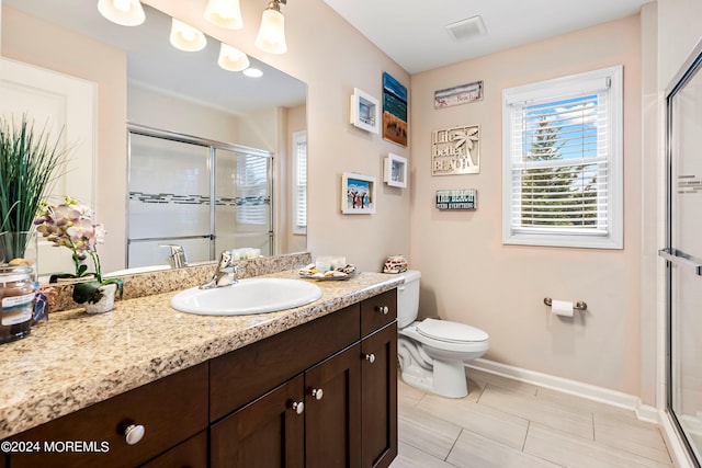 bathroom with visible vents, baseboards, toilet, a stall shower, and vanity