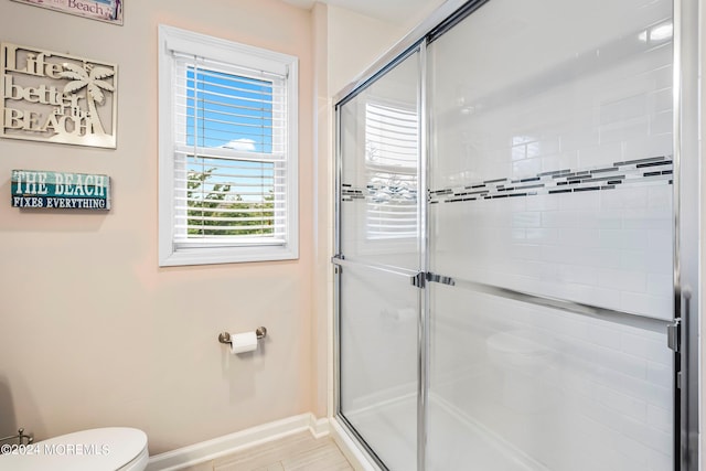 full bath with baseboards, toilet, and a shower stall