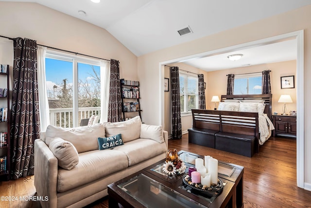 living room with visible vents, baseboards, wood finished floors, and vaulted ceiling