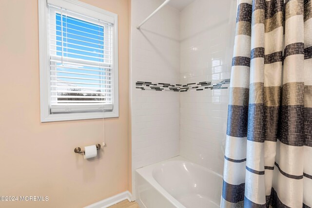 full bathroom featuring shower / bathtub combination with curtain and baseboards